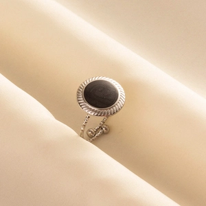 Retro stainless steel open ring with round black stone on soft beige fabric
