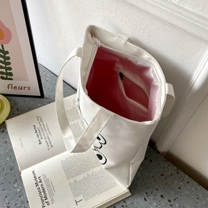 Detailed top view of white canvas tote with pink lining and internal zipper pocket