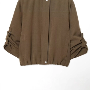 Brown bomber jacket with rolled sleeves and button cuffs detail on white background