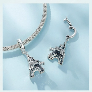 Detailed view of S925 sterling silver Eiffel Tower charms on a sleek snake chain bracelet
