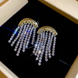 Boucles d'oreilles lune dorées avec pampilles en strass étincelantes dans leur boîte
