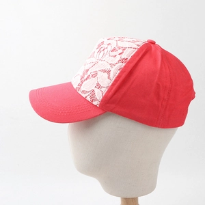 Détail d'une casquette de baseball rose fuchsia avec broderie florale en dentelle blanche