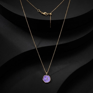 Macro detail of gold-plated chain with purple moon pendant and adjustable lobster clasp