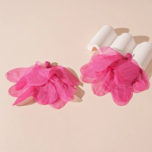 Close-up of pink layered lace flower earrings with woven stud detail on a display stand