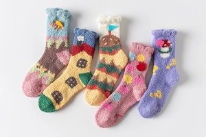 Flat lay of five pairs of thick coral fleece socks with cute cartoon patterns on white background