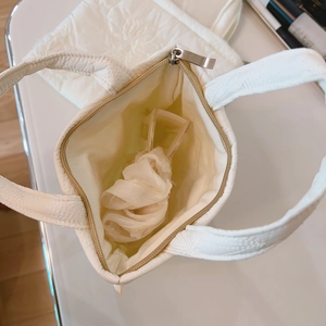 Mini borsa tote trapuntata bianco panna con cerniera argentata e vista dell'interno