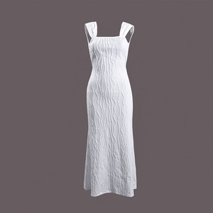 Detail showing white pleated fabric texture and square neck design of the long dress
