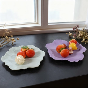 Vue détaillée des plateaux lotus à bords ondulés avec ornements de fruits en résine