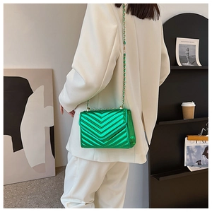 Close-up of vibrant green chevron quilted crossbody bag with metallic finish and chain strap