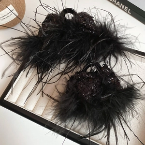 Macro detail of black feather hair claw with sequins showing texture and shiny finish