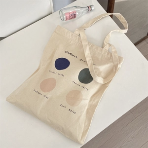 Detail of minimalist cream canvas tote bag with artistic color palette print design