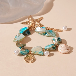 Dettaglio di bracciale stile spiaggia con stella marina, conchiglie e pietre turchesi