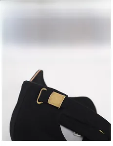 Detailed view of the adjustable bronze metal buckle and strap on a black baseball cap