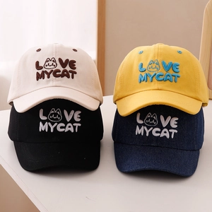 Kids cotton baseball caps featuring cute cat embroidery in four colors on wooden surface