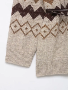 Close-up of oatmeal knit cardigan with brown geometric patterns and leather belt detail