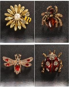 Detail view of insect brooches set featuring bee, spider, dragonfly and ladybug designs