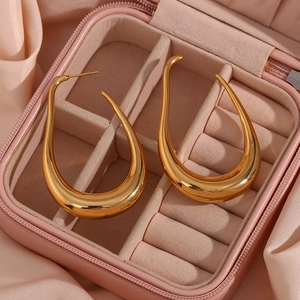 Detailed view of large gold hollow curve earrings in a pink jewelry box