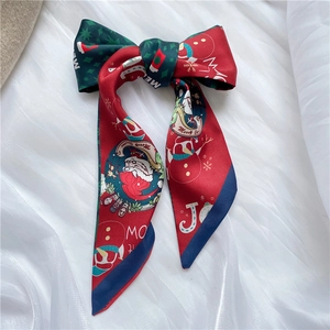 Detailed pattern of festive silk scarf with Santa, snowmen and Merry Christmas text