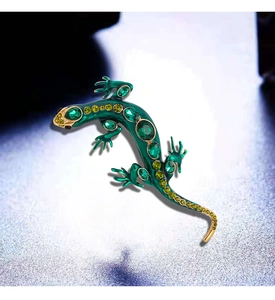 Macro detail of lizard brooch with green enamel, gold finish and sparkling rhinestones