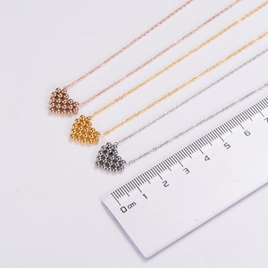 Three beaded heart pendant necklaces in gold, silver, and rose gold with scale measurements