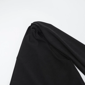 Détail du nœud élégant à la taille sur une combinaison noire à épaule dénudée
