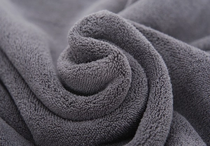 Macro shot of thick deep gray coral fleece fabric showing soft absorbent texture for pets