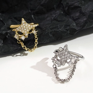 Detail von sternförmigen Ohrmanschetten mit Zirkonia und Ketten in Gold und Silber