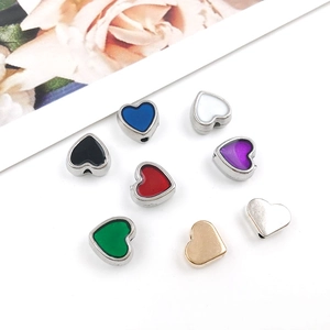 Detailed view of colorful 8mm enamel heart spacer beads on white background