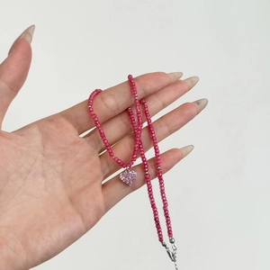 Detailed view of pink beaded necklace featuring a sparkling heart pendant in silver finish