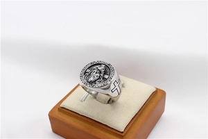 Detailed macro view of vintage silver steel ring featuring Jesus head and black cross symbols