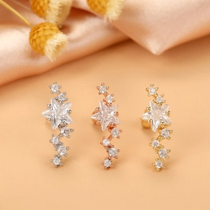 Detailed macro view of star-shaped zircon cartilage studs in silver, gold, and rose gold