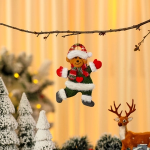 Close-up of a festive Christmas bear plush ornament with a green body and red scarf