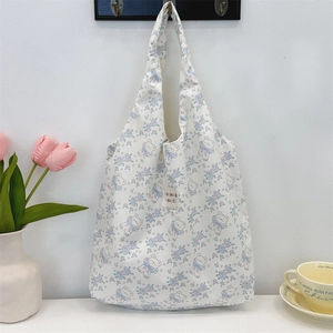 Gros plan d'un sac cabas floral avec motif d'ours suspendu à un crochet mural