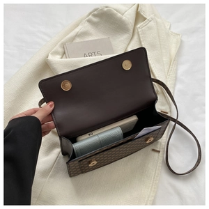 Brown monogram crossbody bag interior with dual magnetic snaps holding a phone and wallet
