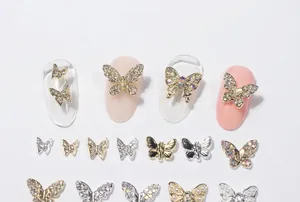 Macro shot of gold and silver butterfly nail charms with micro-inlaid rhinestone details