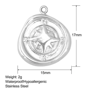 Detailed view of a silver stainless steel compass pendant with N-E-S-W directional engraving