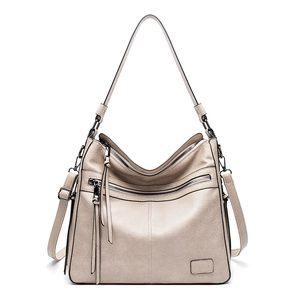 Detail view of beige hobo bag showing soft leather texture and stylish zipper tassels