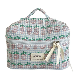 Quilted blue checkered makeup bag with pink floral patterns and ribbon zipper pull