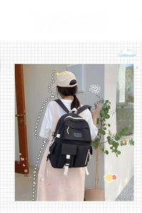 Detail view of black canvas backpack showing adjustable side buckles and durable fabric