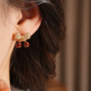 Gros plan détaillé des boucles d'oreilles cerises dorées avec zircons étincelants