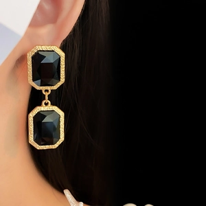 Detail of vintage square crystal tassel earring with gold frame on model