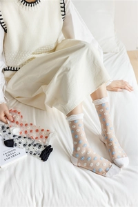 Detail of sheer tulle socks with blue floral embroidery and white wavy edge cuffs