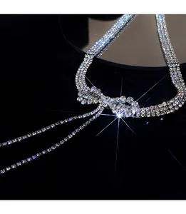 Sparkling silver bow necklace with multi-row rhinestones on dark velvet background