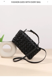 Close-up of black woven leather shoulder bag with classic Intrecciato pattern detail