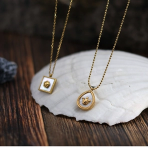 Detail of vintage 18K gold plated necklaces featuring rose and crown shell pendants