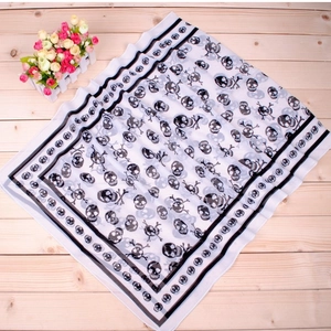 Detail of classic pirate skull print on long chiffon scarf over a wooden background