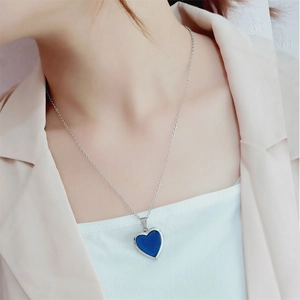 Close-up of a heart-shaped thermochromic pendant necklace on a silver stainless steel chain