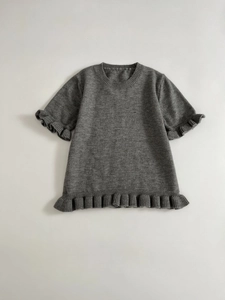 Detail of grey short sleeve knit top showing organza pleated edges and ribbed texture