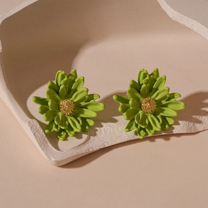 Detailed close-up of green layered flower stud earrings with golden textured stamen