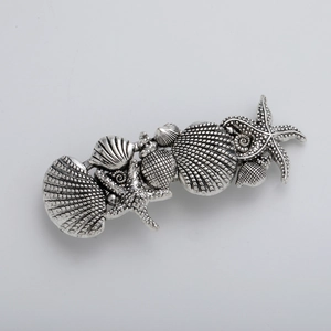 Detail of vintage silver hair clip featuring intricate starfish and seashell metal textures